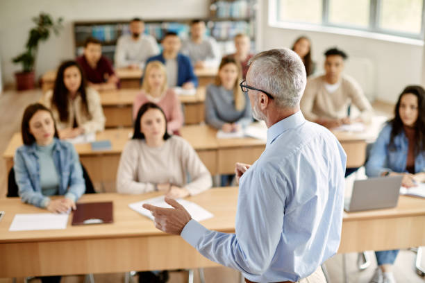 Teacher guiding students in a university classroom