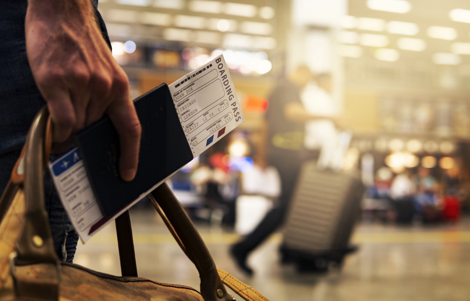 Man holding a passport with a boarding pass in an airport